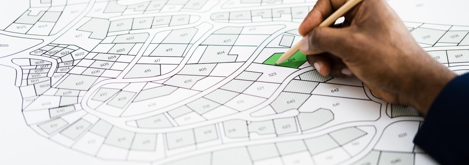 Picture of a planning map with someone gridding out plots.
