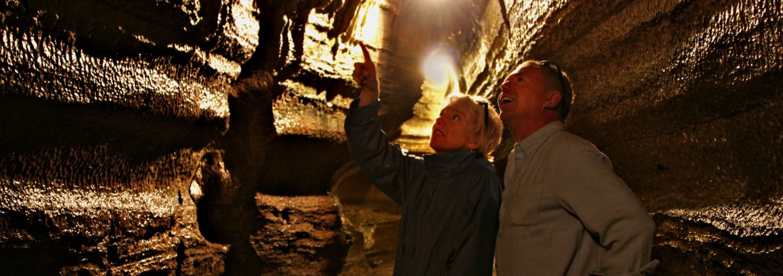 A man and woman exploring a cave.