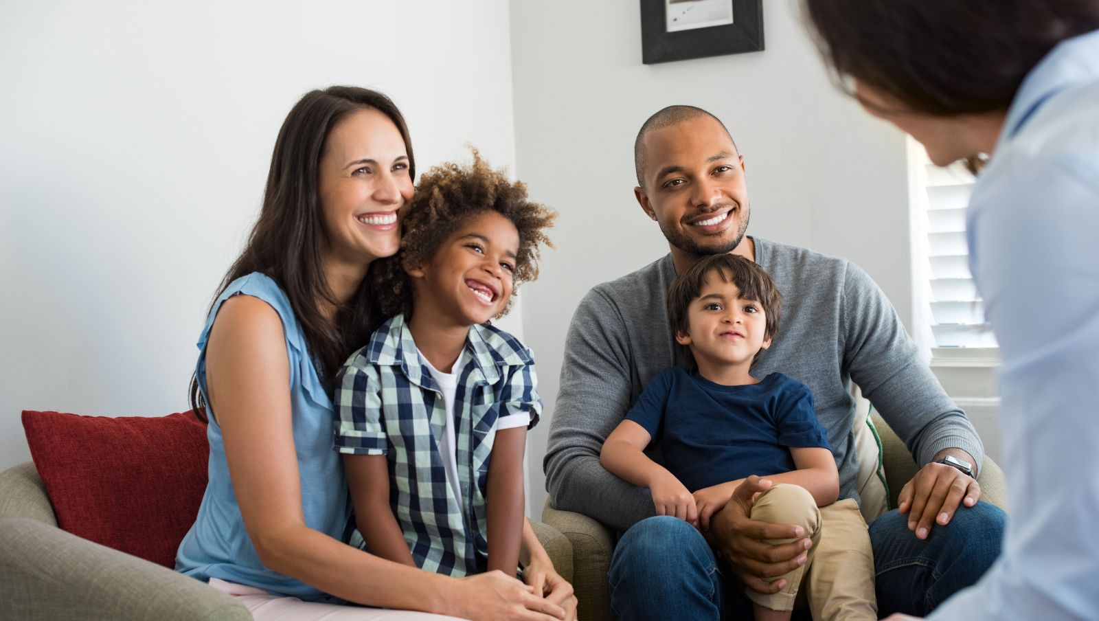 A man, a woman, and child smile as they talk with an advisor.