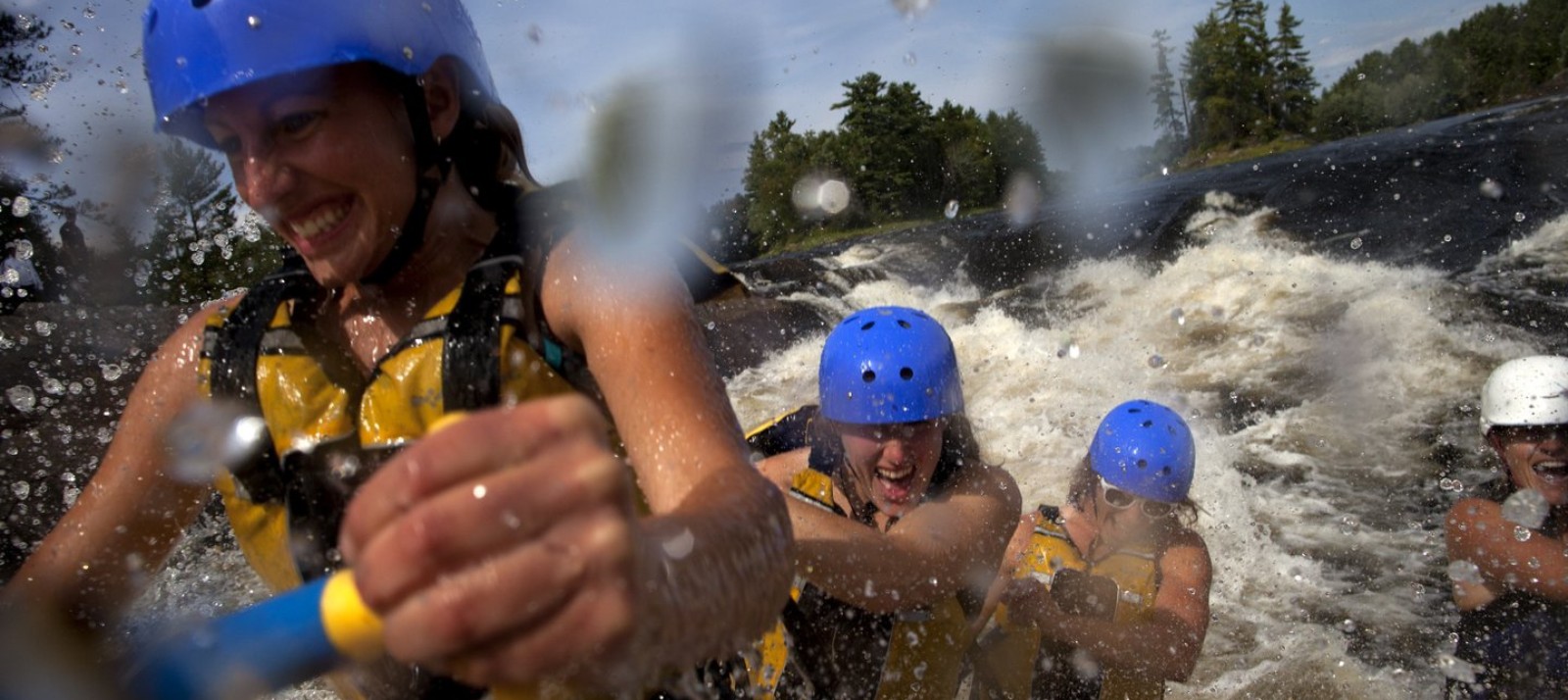 A group smiling while whitewater rafting.