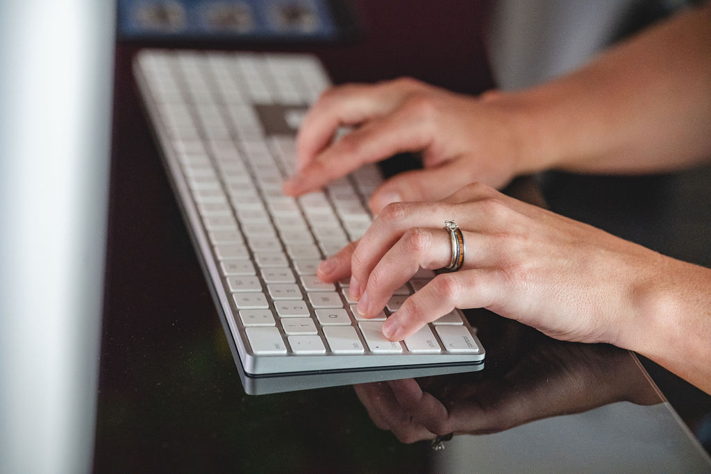 Hands typing on a computer