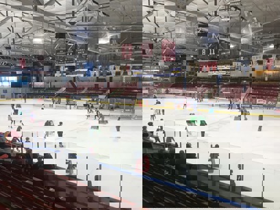 A group of people ice skating in a rink.