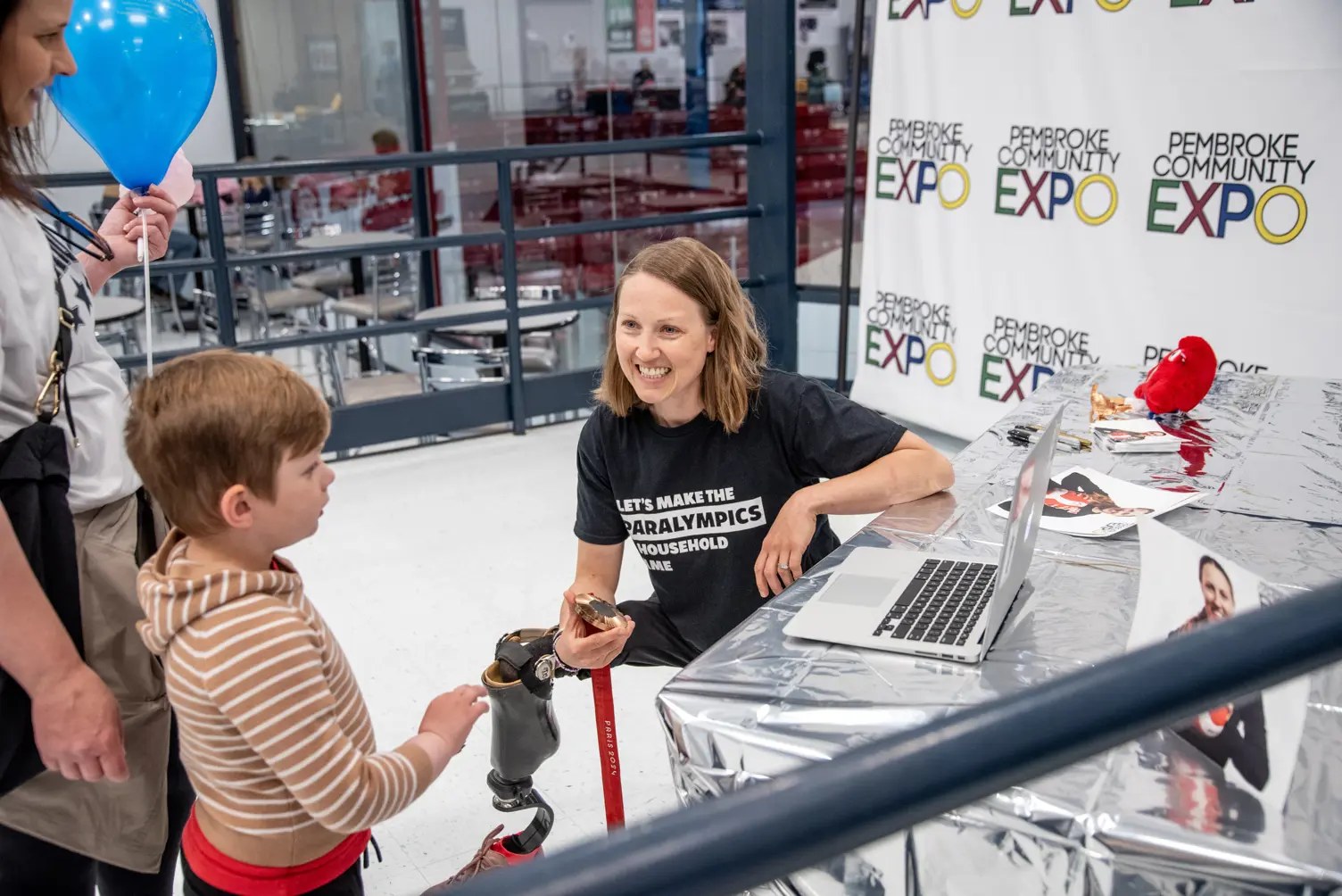 A child speaking to a Paralympian.