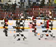 Two hockey players battle for a puck.