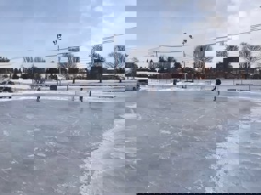 People skate on an outdoor rink.