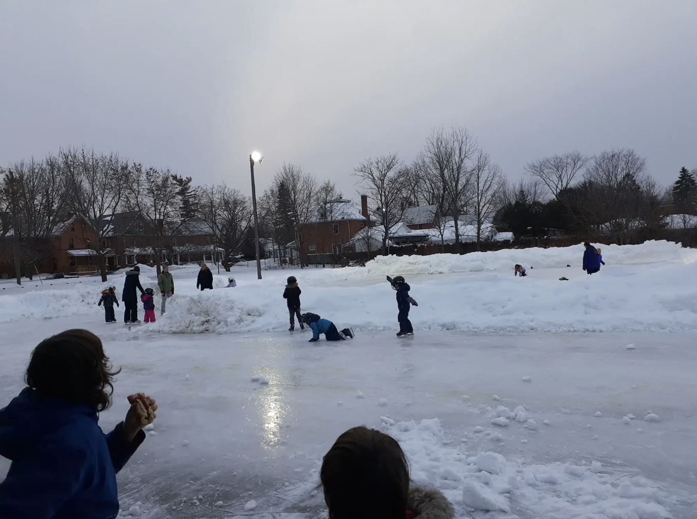 Kids skating at an outdoor rink.