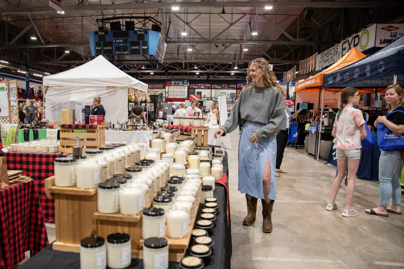 A woman looks at a display of candles.