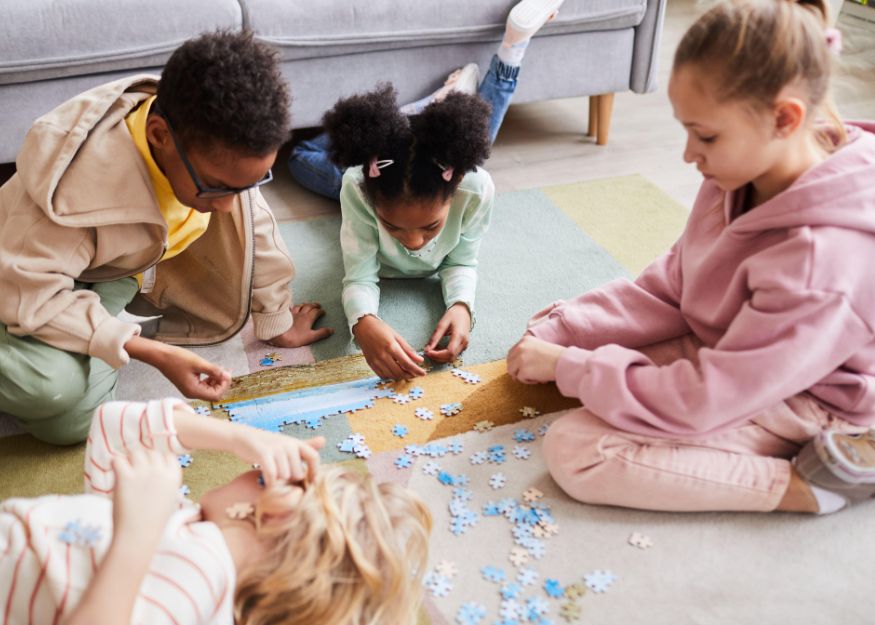 Kids doing a puzzle on the floor.
