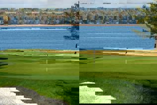 A golf green overlooking a river.